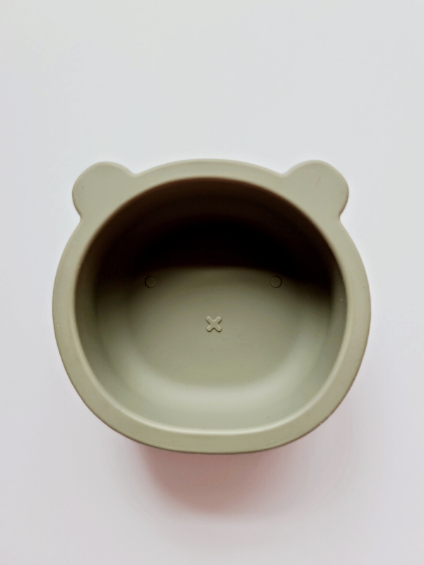 Sage coloured silicone bowl, with suction cup base, in the shape of a bear's face.