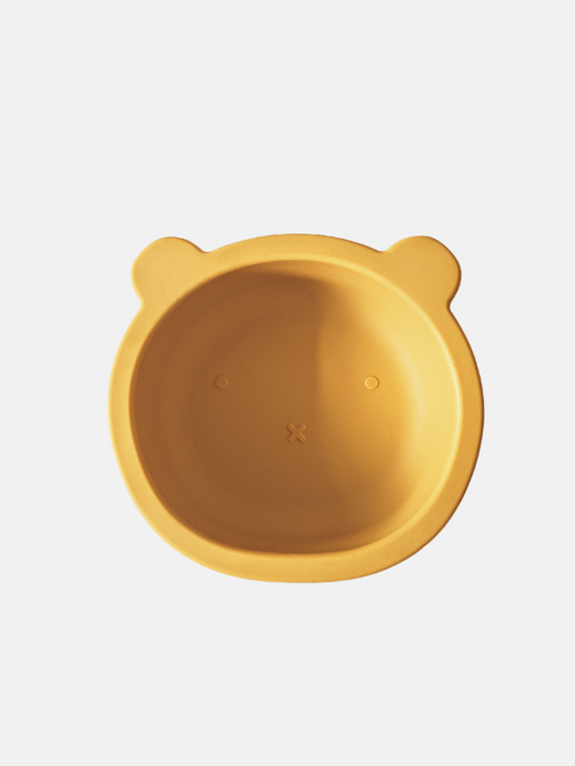 Mustard yellow coloured silicone bowl, with suction cup base, in the shape of a bear's face.