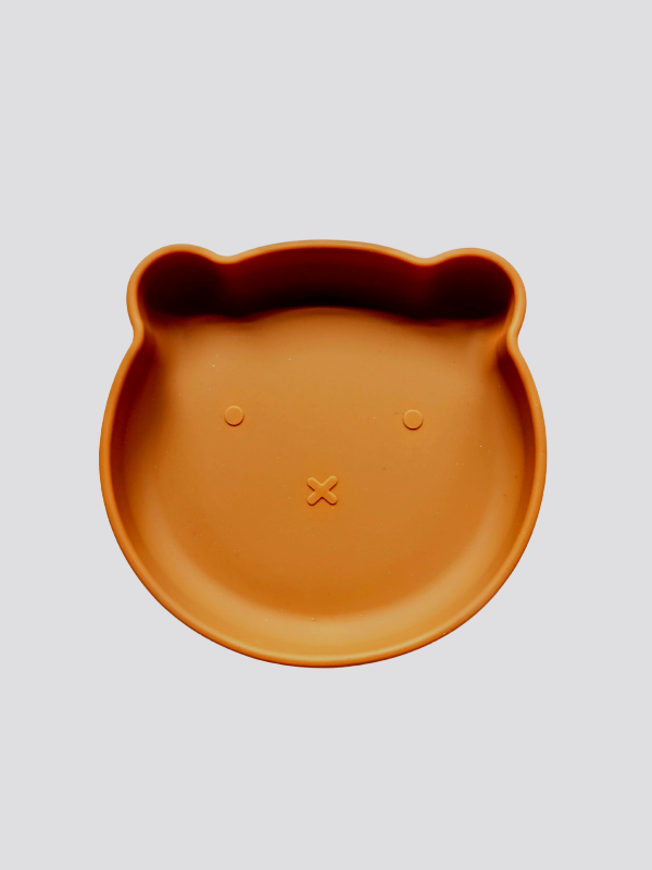 Burnt orange silicone plate, with suction cup base, in the shape of a bear's face.