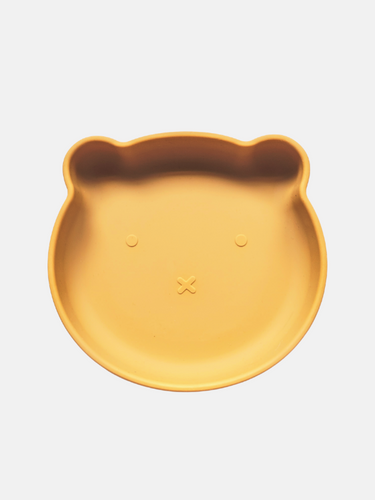 Mustard yellow silicone plate, with suction cup base, in the shape of a bear's face.