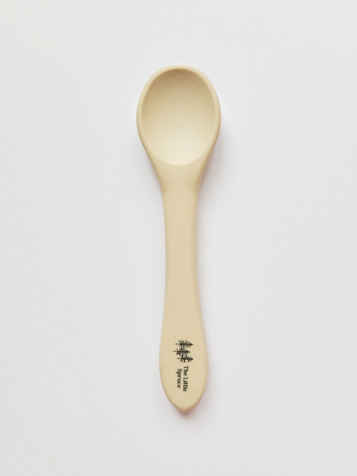 A small sand coloured silicone spoon meant for use by babies and toddlers.